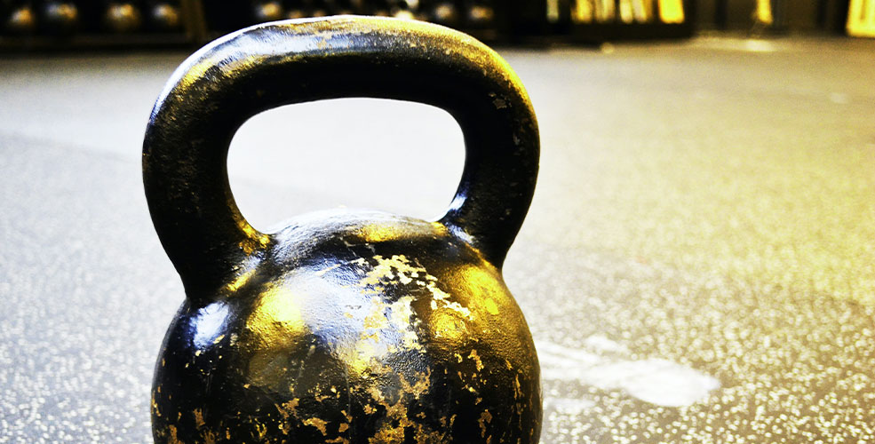 Sort kettlebell der står på et stengulv